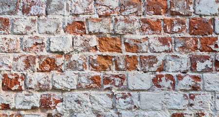 Ancient ruined brick wall with paint residue. Brick weathering. Selective focus