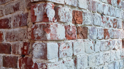 Ancient ruined brick wall with paint residue. Brick weathering. Selective focus