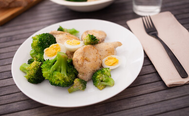 Chicken breast with broccoli and quail eggs on plate for healthy dinner