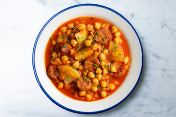 Delicious dish of braised chickpeas with spicy chorizo. Top view food table.