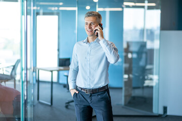 Smiling Businessman Talking on Phone in Modern Office