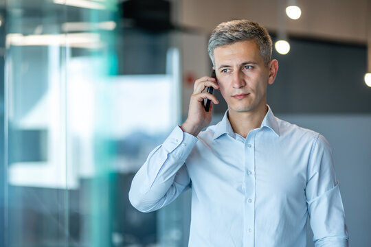 Businessman Talking on Smartphone in Modern Office Setting