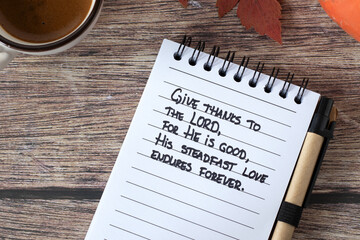 Christian handwritten quote in notebook for giving thanks to the LORD with coffee cup and autumn...