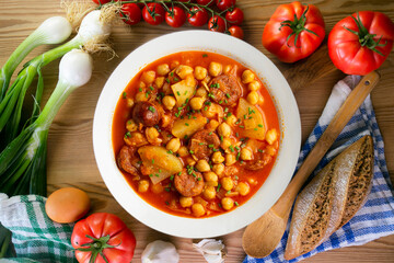 Delicious dish of braised chickpeas with spicy chorizo. Top view food table.