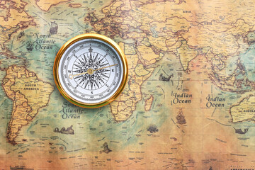 Classic round compass on background of old vintage map