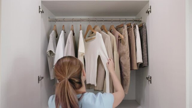 The way forward Less is more buy few second hand eco shirt reduce clothing issue zero waste fast fashion. Go green woman happy neat chaos clutter home young adult asia people slow reuse repeat closet.