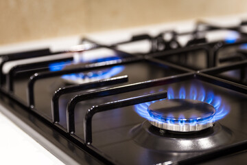Blue flames on gas stove burner at home