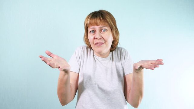A young woman spreads her hands in disbelief, expressing disappointment and frustration. The offended woman is indignant. Negative emotions concept.