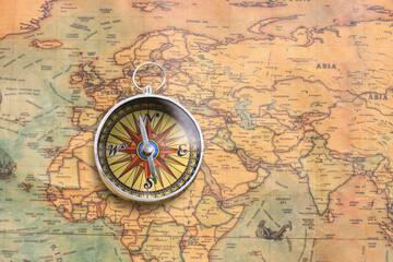 Classic round compass on background of old vintage map