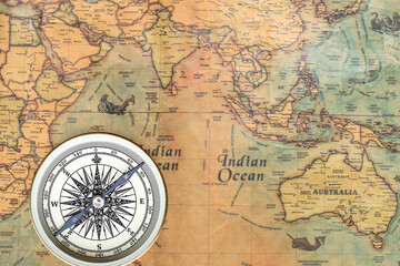 Classic round compass on background of old vintage map