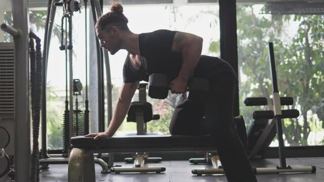 man doing weight training One Arm Dumbbell Row in the gym