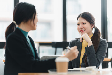 Engaging conversation between two women in modern office setting.