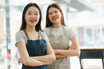 Fototapeta premium Empowered women in aprons smiling confidently in cafe setting