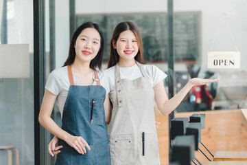 Fototapeta premium Welcoming baristas in aprons stand proudly by open sign.