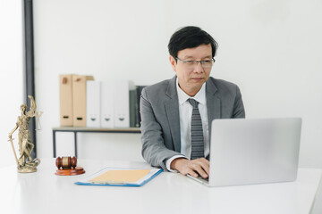 Efficient lawyer working on laptop in modern office setting.
