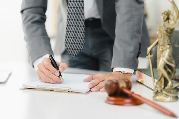 A professional man writing notes in legal setting, showcasing determination and focus.