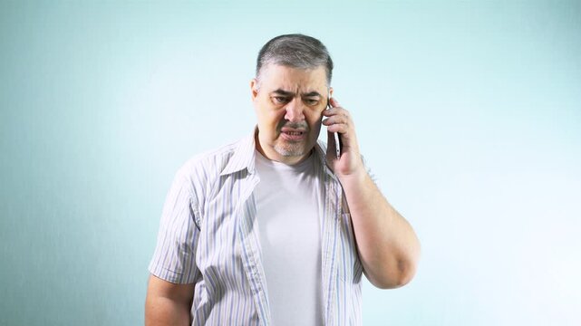 A man swears on the phone. He screams and gestures. The concept of difficulties in communication, misunderstandings, differences of opinion, emotional burnout.