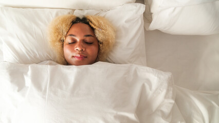 Banner with young African American woman with white curly hair sleeping in bed under white blanket. Sound sleep in cozy bedroom. Sleeping pill and sedative for insomnia.