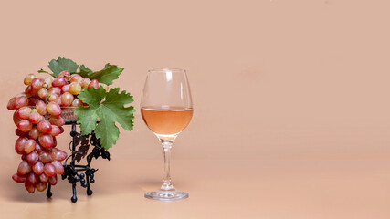 Pink wine and pink grapes in a vase on background with copied space for text.