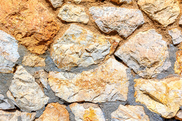 Textured wall composed of various sizes and shapes of rocks. Natural stone patterns. Wall is made of stones and has a rough texture