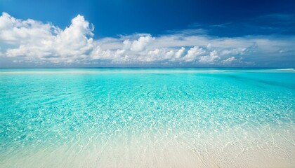 Fototapeta premium Clear turquoise water with white sand bottom and blue sky with white clouds.
