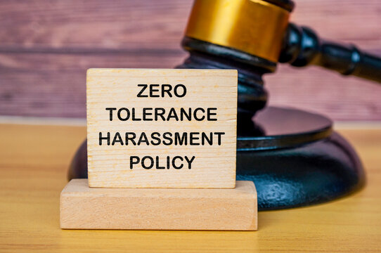 Zero tolerance harassment policy text written on wooden board with lawyer's gavel background