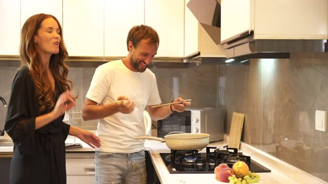 Romantic Kitchen Scene: Tasting Food Straight from the Pan. Happy family