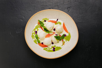 Elegant gourmet dish with cheese balls, herbs, and grapefruit, dining and culinary presentations