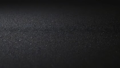 Dark textured surface with a subtle gradient from black to dark grey.