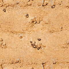 Fototapeta premium Desert sand texture rough surface with small rocks and pebbles, yellow and orange beach sand material