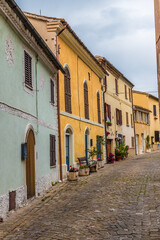 A view of the top end of the main street in the hilltop fortress village of Sant Andrea di Suasa, Italy in summertime