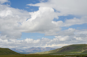 Mountain slopes with clouds on the sky covered with valley on top and mountains in Altay Russia early in the evening sunset. Hight quality horizontal photo