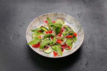 Fresh vegetable salad with arugula, cucumbers, tomatoes, and red onions - healthy food projects
