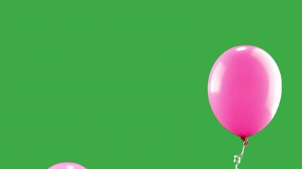 pink balloons rising up on green screen