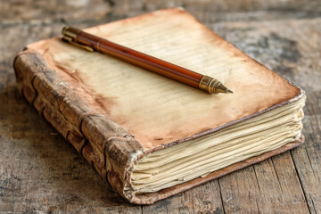 A pen sits on top of a book with a yellow cover