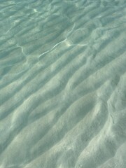 Clear water reflections on shallow sandy beach bottom, Maldives in a summer day