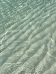 Clear water reflections on shallow sandy beach bottom, Maldives in a summer day