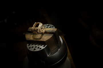 Jeweler puts diamond to golden wedding luxury ring.