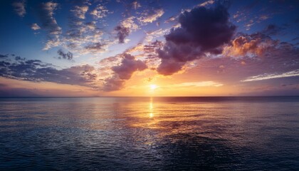 Obraz premium Peaceful sunrise over a calm ocean with colorful clouds