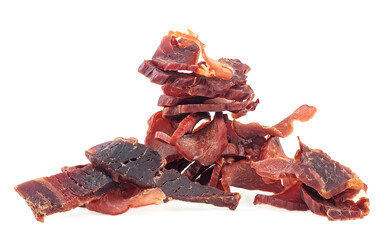 Pile of dried meat, pork jerky isolated on a white background. Tasty hearty meat.