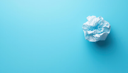 Fototapeta premium Crumpled paper on a bright blue background, symbolizing creativity, brainstorming, or ideas in progress.