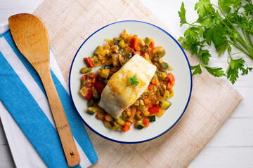 Cod with baked vegetables traditional Spanish recipe. Top view food.