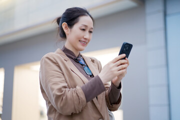 Smiling Woman Using Smartphone in Urban Environment