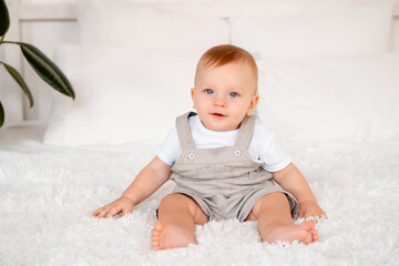 Happy baby boy laughing or smiling on the bed at home, joyful baby