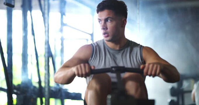 Gym, workout and man with rowing machine for fitness, training and muscle health with challenge and power. Strong person or body builder thinking with pull cable for upper strength and exercise goals