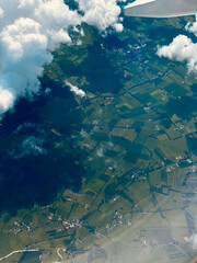  Aerial view of farmland and buildings from an airplane window during flight.