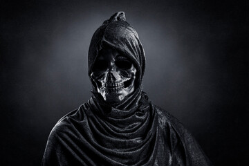 Grim reaper over dark misty background