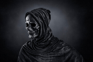 Grim reaper over dark misty background