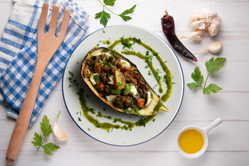 Eggplant stuffed with tomato and baked mozzarella. Top view food table.