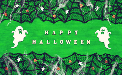 Halloween background. Inscription Happy Halloween and Halloween elements on the bright green wooden background, Happy Halloween concept